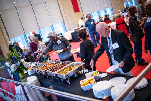 Folks filling their plates with delicious breakfast foods at the Retiree Brunch 2022