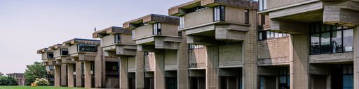 General campus shot of building exterior on sunny day with blue skies and green grass