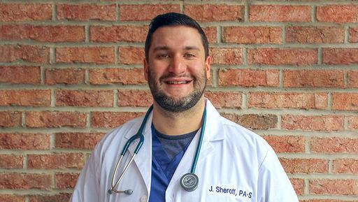 Jonathan Sheroff pictured in new lab coat and scrubs