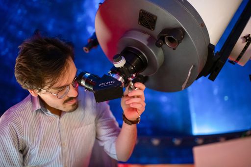 Physics student looking into a telescope in the campus observatory
