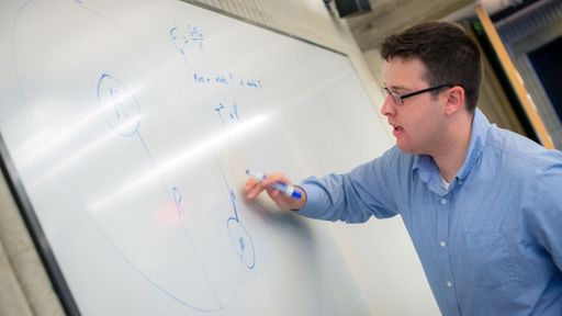 Physics student, William Holman '21, writing an equation on the whiteboard