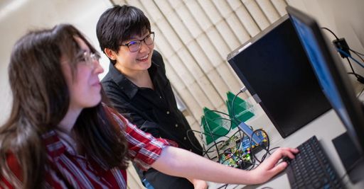 Electrical & Computer Engineering Professor Ruolin Zhou conducting research, with students, in the lab