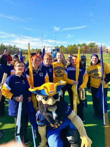 Colorguard members posed with mascot