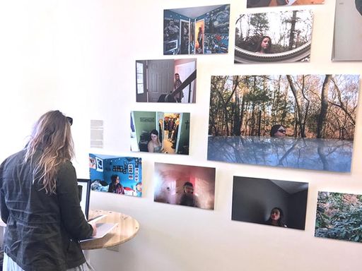 student standing by wall of photographs