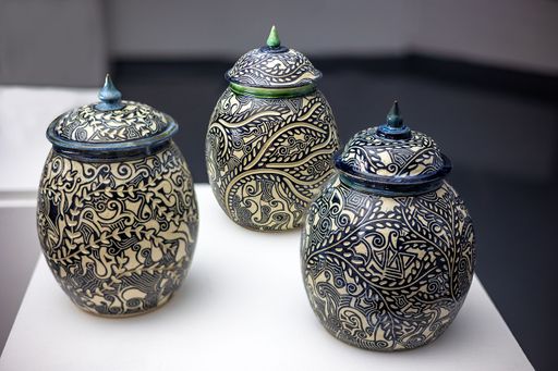 Subconscious Sgraffito, 2023, a green and two blue jars with varying rounded forms and pointed finials with detailed designs of various marks and depth, 11 ½ x 7 ½ in, 12 x 8 in, 11 x 8 in.