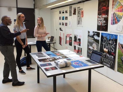 Prof. Ziddi Msangi in graphic design critique with students