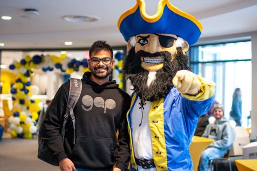 UMD mascot Arnie the pirate with student at Countdown to Commencement event.