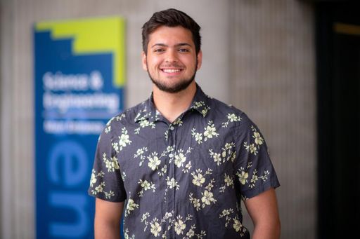 Computer Science Student Cameron McAlpine '23 standing in front of the SENG building sign