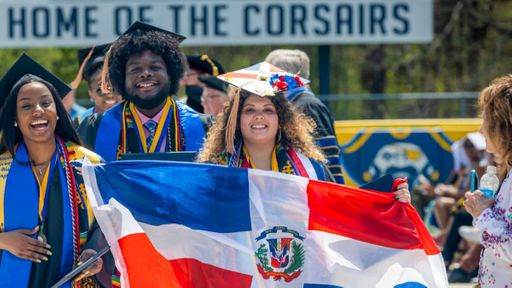 Adriana Lebreault carries a Dominican Republic flag at commencement