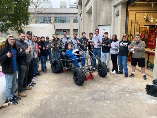 ASME students gathered around the Baja vehicle