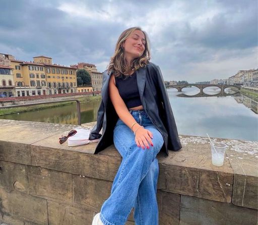Mabel Ferreira seated on a bridge in Florence, Italy