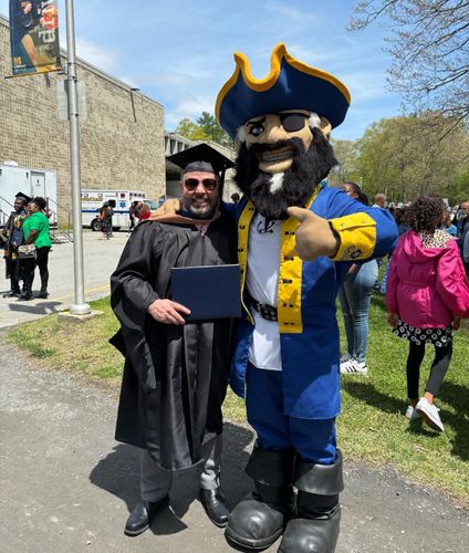 Giesta poses with campus mascot, Arnie, at commencement.