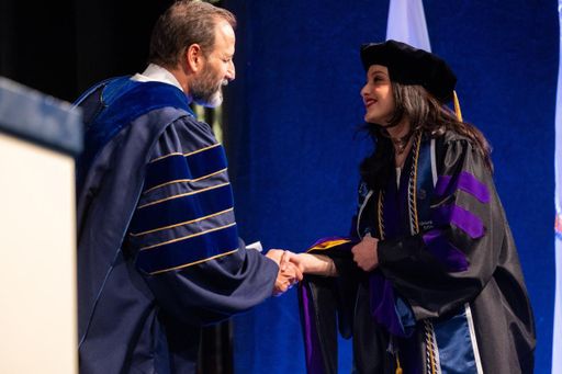 Aguilar Delgado pictured at commencement shaking the hand of UMass Law Dean Sam Panarella.