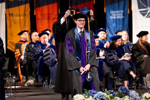 Riley is hooded at the 2026 commencement ceremony.