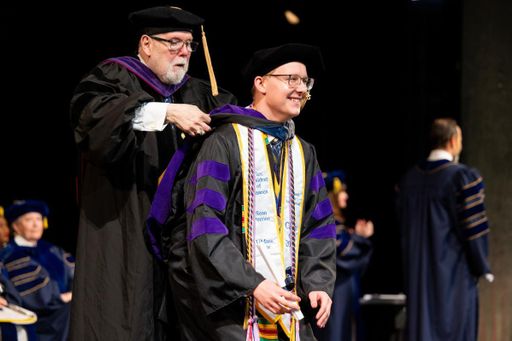 Sean Perrine receives his hood from Professor Phillip Cleary at the School of Law commencement.