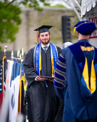 Collin Farr approaches Chancellor Fuller on the Commencement stage.