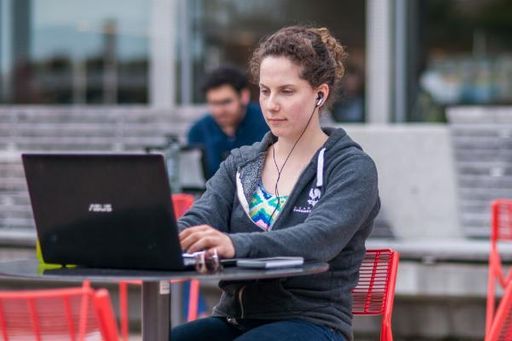 Woman on laptop with earbuds in