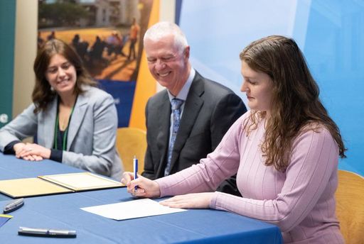 Molly Gedutis signing her certificate with Chancellor Fuller
