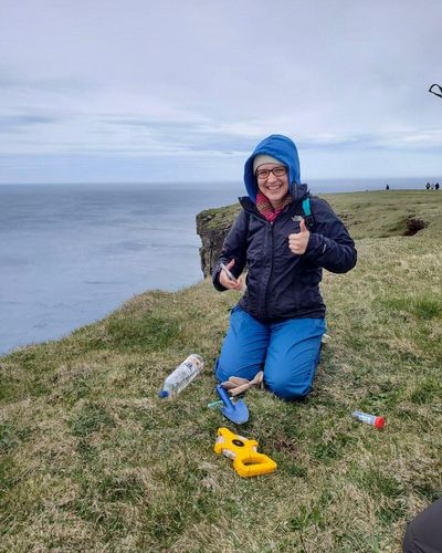Biology major Eva Lavoie working on a cliff on the coast of Iceland.