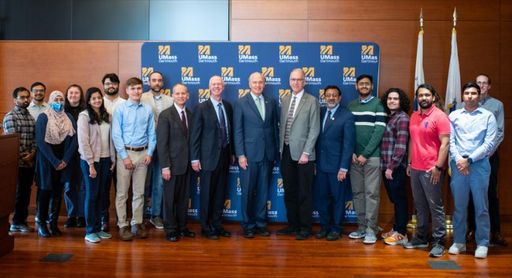 Students, faculty, and elected officials pose on stage