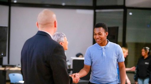 Students cross the podium and become degree candidates at UMass Dartmouth.