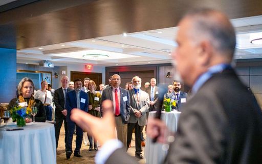 Charlton College of Business Dean Madan Annavarjula addresses a room of alumni, business leaders, and legislators in Boston.
