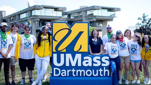 Corsairs standing around UMassD Logo statue