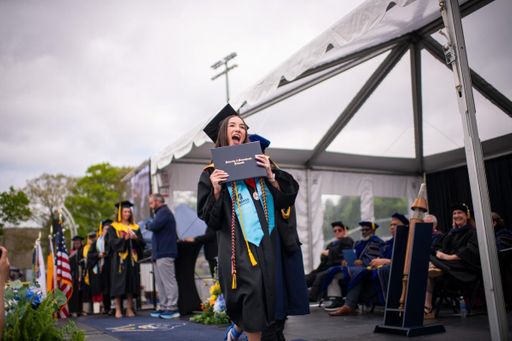 student crossing the graduation stage