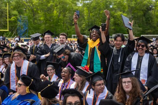 Students celebrate after crossing the stage at Commencement.