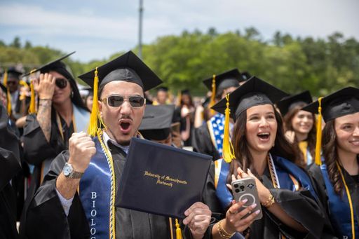 Students pictured with their diploma covers after crossing the stage at Commencement.