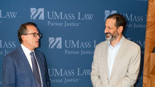 Bristol Wealth Group President and CEO Lou Ricciardi presents a $10,000 check to UMass Law Dean Sam Panarella.