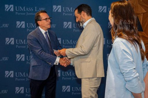 Bristol Wealth Group President and CEO Lou Ricciardi presents a $10,000 check to UMass Law Dean Sam Panarella.