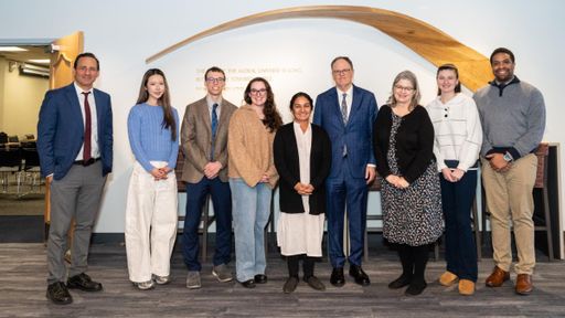 UMass Law Dean Sam Panarella, students, and justices of the Massachusetts Appeals Court pose in UMass Law's lobby.