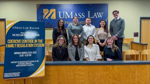 Members of the executive board of the UMass Law review pose in the Moot Court Room.