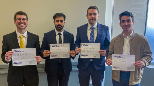 UMass Law students pose with the reason they walk—to improve access to justice, for immigration, education, and equal access.