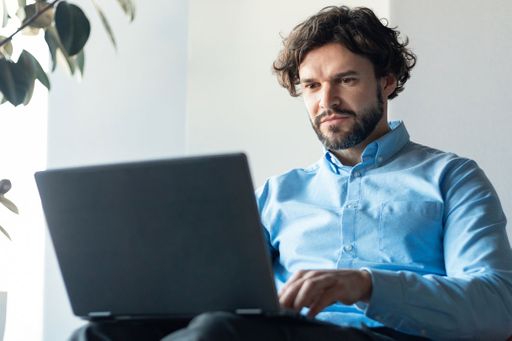 Adult man on his laptop sitting on the couch