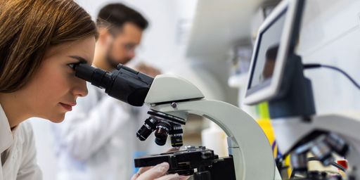 Student in a lab using microscope.