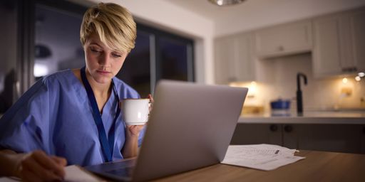 Healthcare professional working on her laptop at night