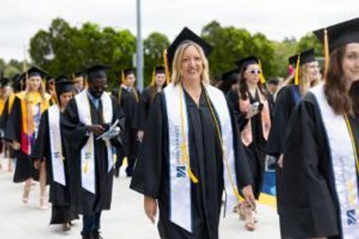 UMassD Online Student walking at commencement ceremony