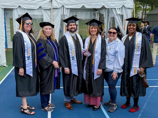 UMassD Online Students posing at commencement ceremony with advisor