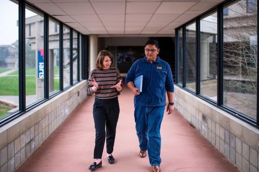 Student walking with faculty in hallway