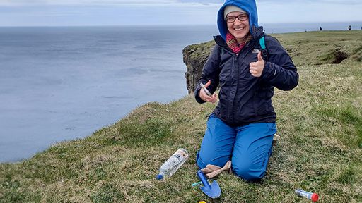 Biology major Eva Lavoie working on a cliff on the coast of Iceland.