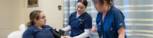 Nursing faculty working with students in the clinic