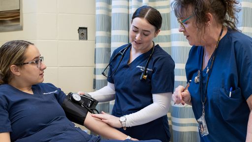 Nursing faculty working with students in the clinic
