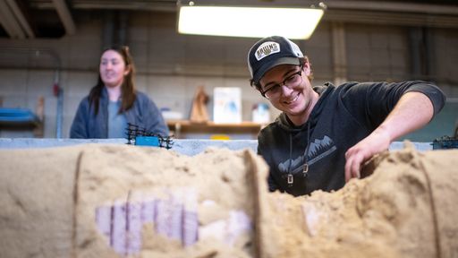 Civil Engineering students working on a concrete canoe in the ASCE lab