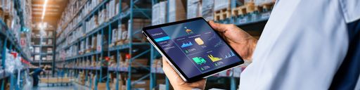 Hands holding a tablet in a warehouse