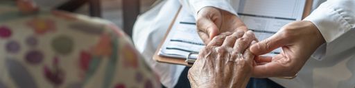 Nurse's hand holding the hand of an elderly person