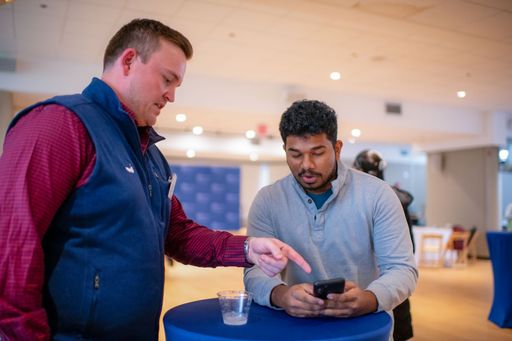 Senior Shift Spring 2024: student and staff member looking at a cell phone