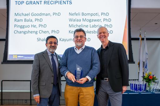 Dr. Michael Goodman being awarded for the Top Grant Recipient Award by Dr. Ramprasad Balasubramanian and Chancellor Mark Fuller.