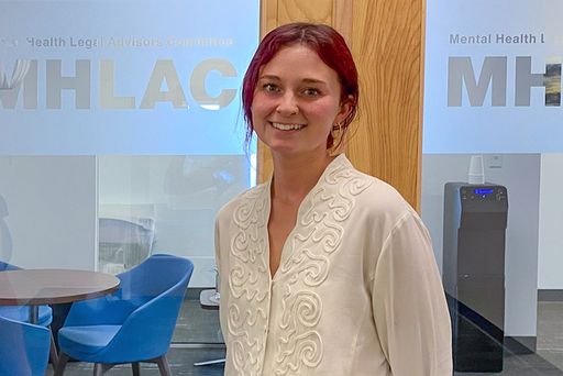 Law student standing in front of inside door at internship